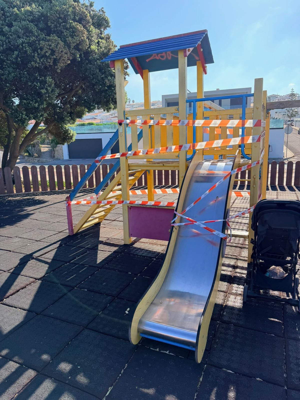 Torre principal de um parque infantil vedada com fita de sinalização vermelha e branca.